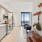 Well-lit studio apartment at The Leaf featuring large windows with stunning city views.